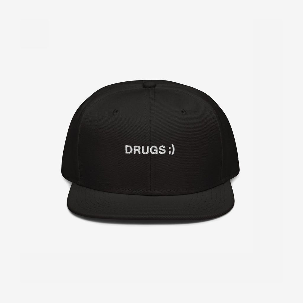 Black flat-brim snapback cap with DRUGS ;) embroidered in white, offering bold, edgy style. Ideal for making a statement, this hat aligns with the store's ethos of supporting equality and diversity.