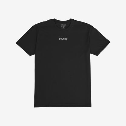 Drugs T-shirt featuring a minimalist design with DRUGS ;) in white on black, embodying an ironic and unapologetic message. Brand name STRANGE ALLIES. is faintly visible inside the collar.