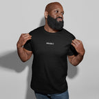 Muscular man wearing a black Drugs T-shirt with ironic text, pulling the shirt to emphasize its bold design, capturing the unapologetic and minimalist style that defines the product's message.