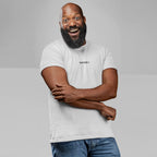 A smiling bald man models the Drugs T-shirt, featuring DRUGS ;) on the chest in black. He wears it casually with blue jeans, embodying the tee's bold, unapologetic message.