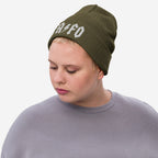 Young person wearing the FAFO Hat, an olive-green knit beanie with bold white lettering and a lightning-bolt graphic, embodying a bold, resistance-driven style against fascism and extremism.