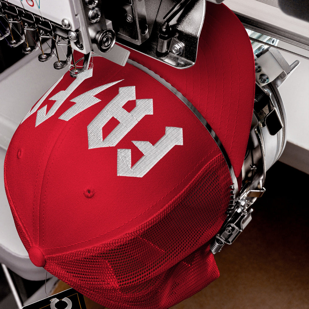 The FAFO Hat on an embroidery machine, showcasing bold white lettering on its front panel, embodies a hard rock aesthetic, ideal for expressing resistance against extremism.
