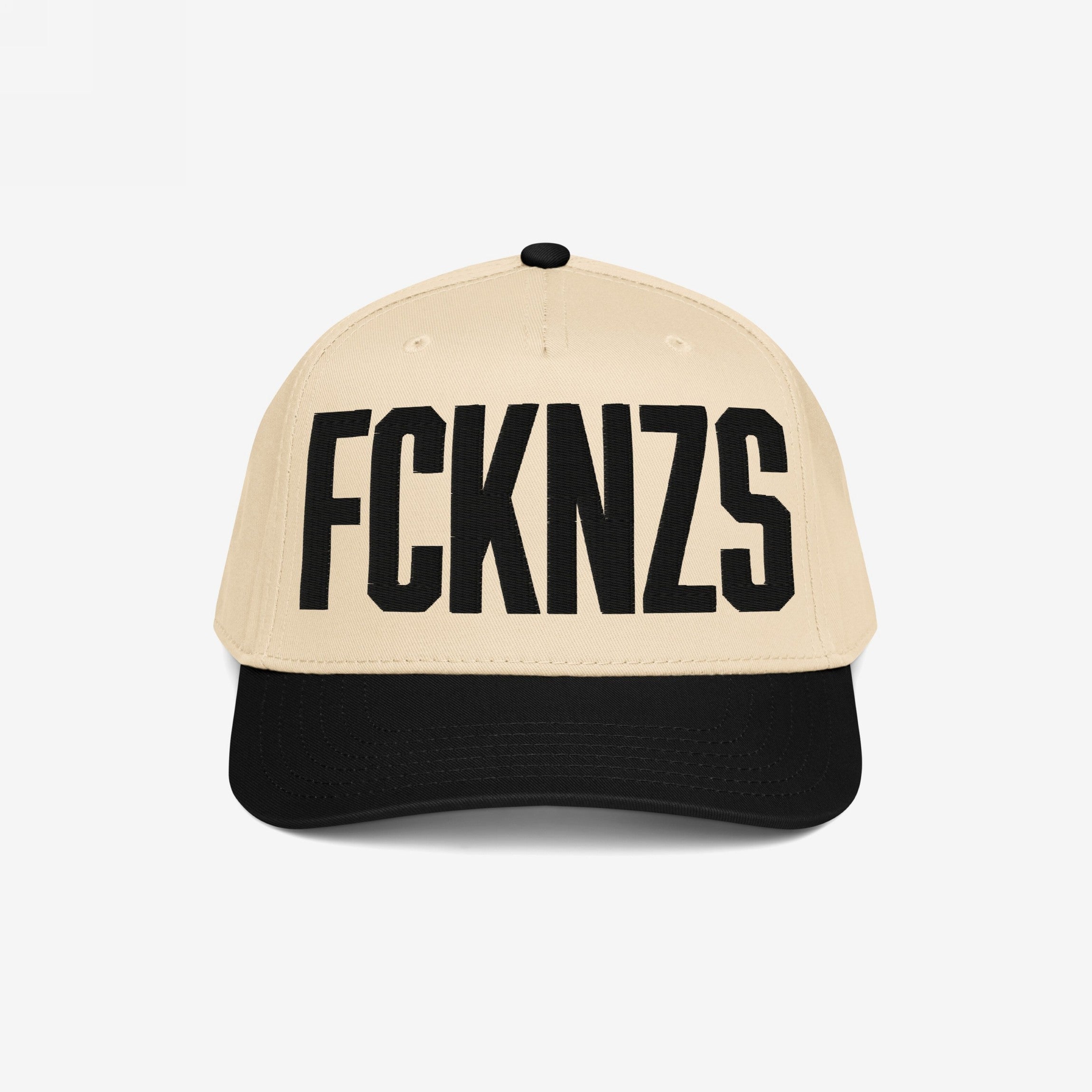 Two-tone FCKNZS Hat with beige crown and black brim, featuring bold black letters FCKN7S on the front, embodying a strong anti-fascist message in an everyday wearable design.