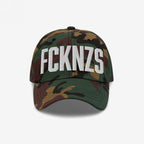 Camo-patterned FCKNZS Hat with white embroidered block letters on the front, expressing anti-fascist sentiments. Ideal for marches and daily wear, showcasing a clear stance against hate.