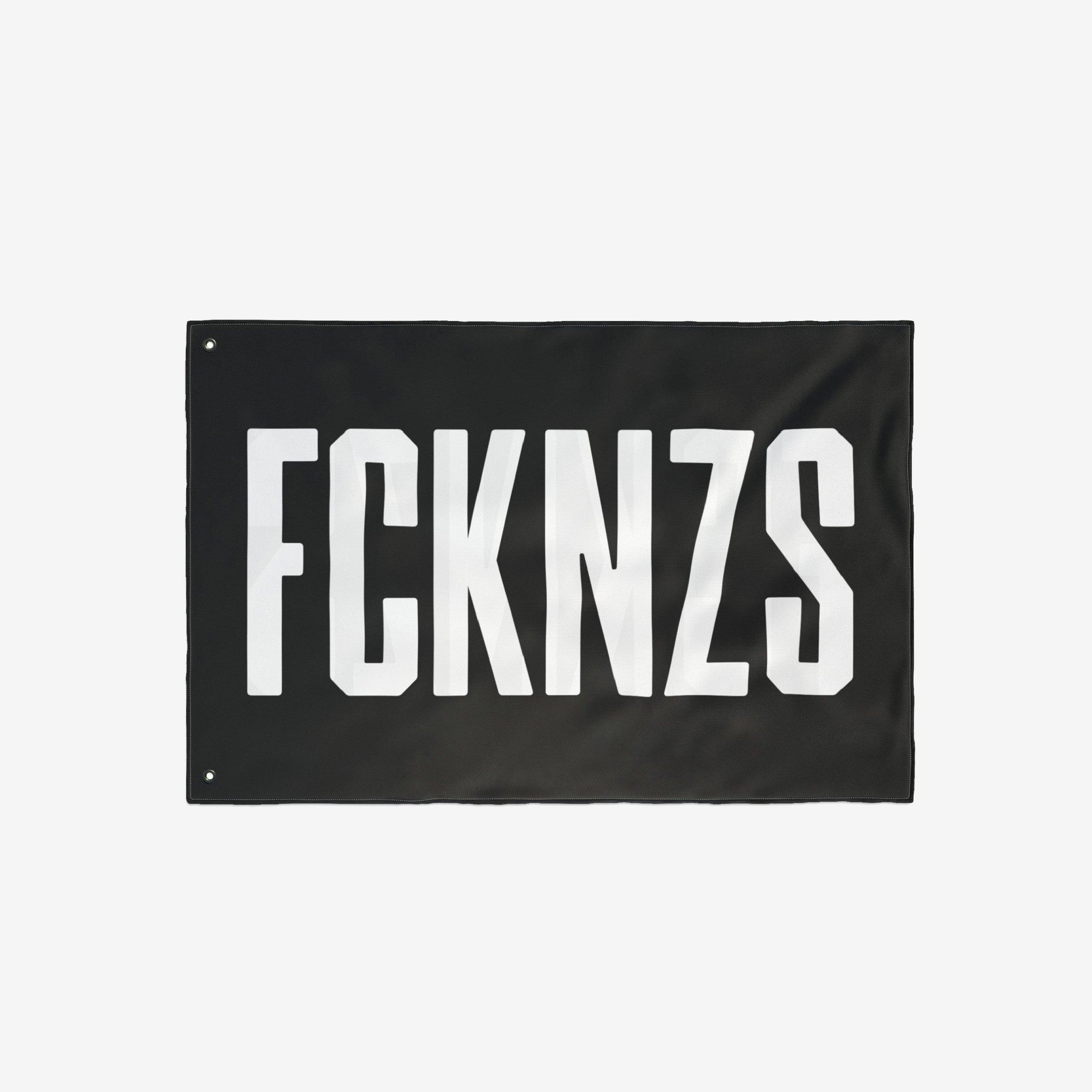FCKNZS Flag - A bold black banner with FCKNZS in white block letters, featuring metal grommets for easy display. A visible anti-fascist statement for home or public spaces.