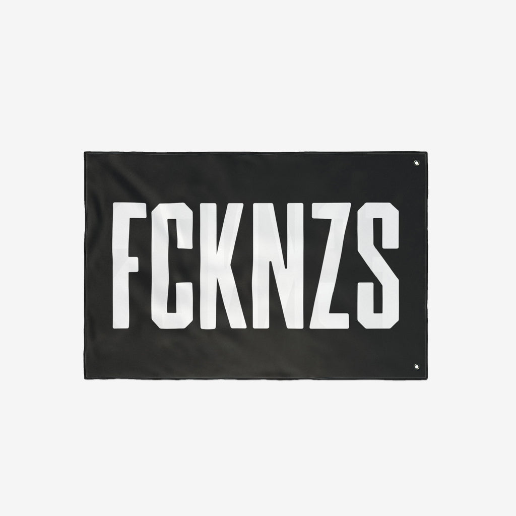 FCKNZS Flag with bold white text on a black background, featuring metal grommets for easy hanging. Designed for anti-fascist expression, suitable for home display or protests.