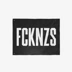FCKNZS Flag: A black banner with bold white letters FCKNZS, featuring metal grommets, designed for anti-fascist expression. Ideal for displaying firm boundaries against hate, available in various sizes.