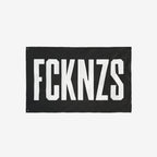 Black FCKNZS flag with bold white letters, symbolizing anti-fascism. Ideal for home display or protests, this double-sided flag comes in four sizes to make a powerful statement against hate.