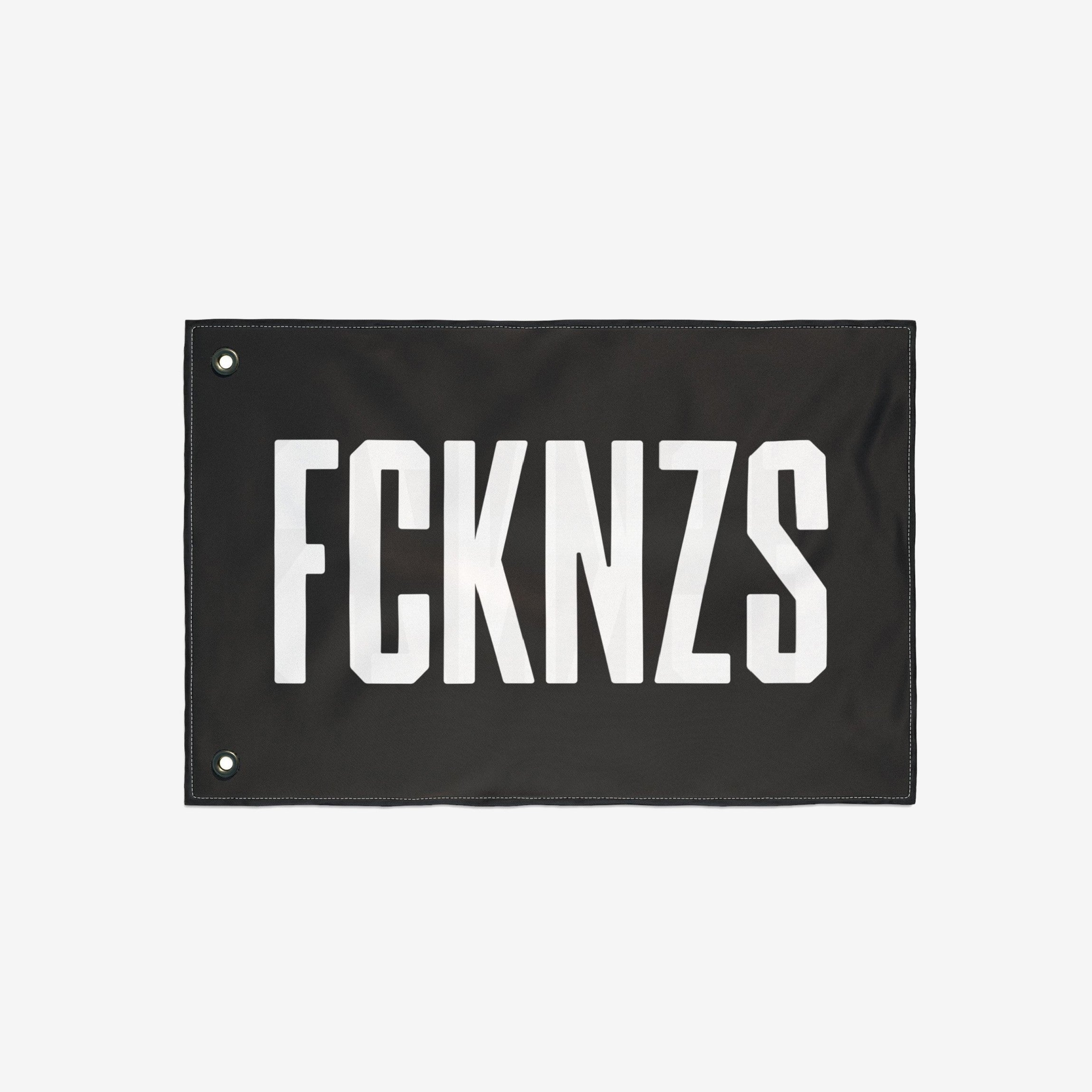 FCKNZS Flag with bold white text on black fabric, featuring metal grommets for easy hanging. Ideal for anti-fascist statements at home or events, available in multiple sizes for impactful visibility.