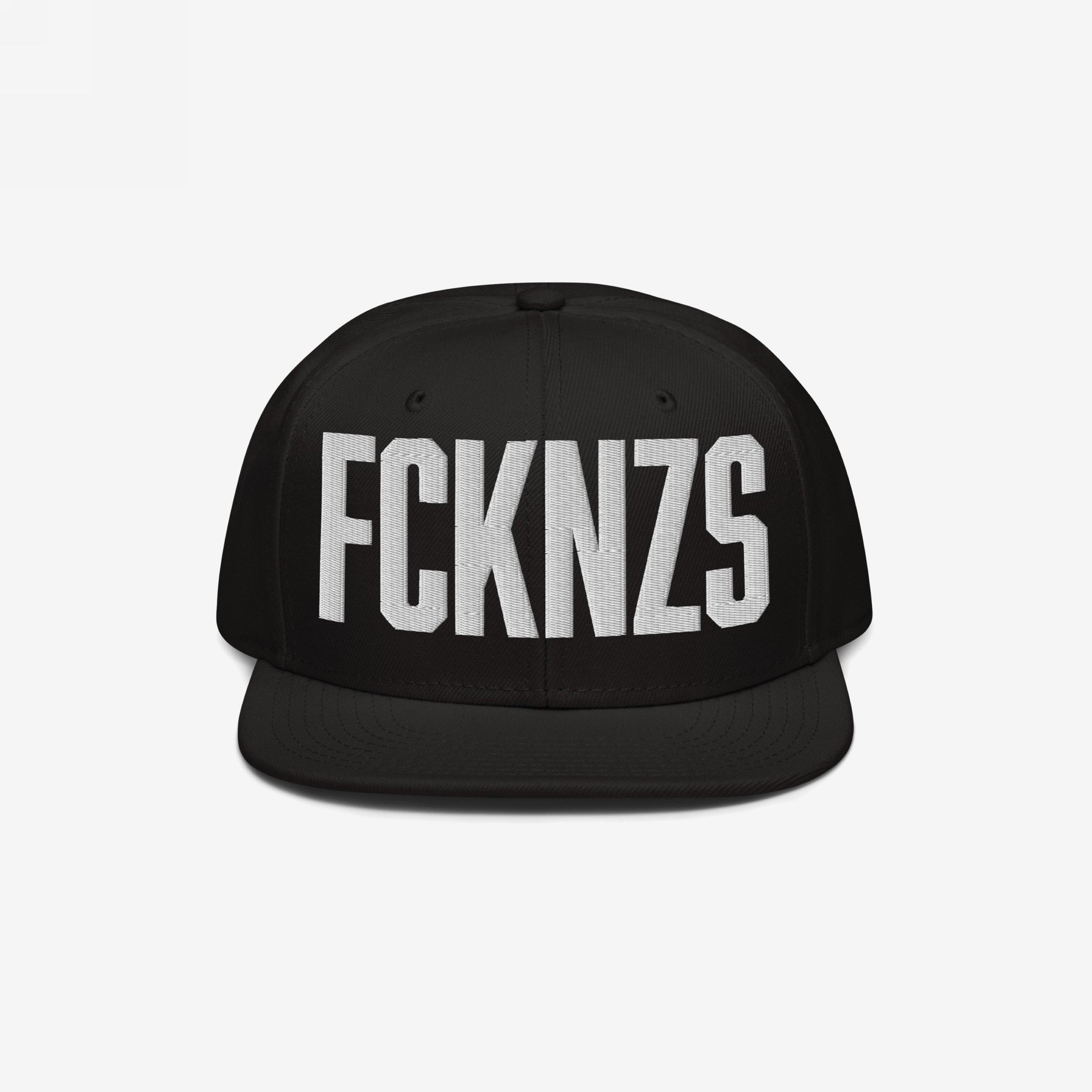 Black flat-brim snapback hat featuring bold white embroidered letters FCKNZS, representing an anti-fascist stance. Designed for visibility in protests, shows, and daily life, conveying a strong message.