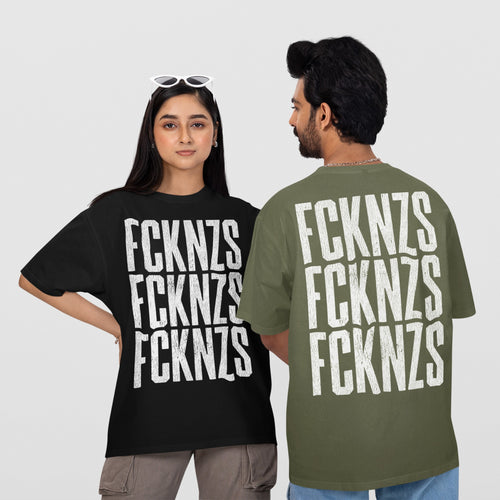 Two models showcase the FCKNZS T-shirt with bold, distressed lettering. The woman in black faces forward, while the man shows the olive-green back print, representing an anti-fascist statement.