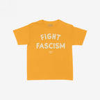 Fight Fascism Women's Baby Tee in mustard, featuring large distressed white text FIGHT FASCISM and smaller brand lettering. Designed as a retro Y2K style for activism, protests, and equality support.