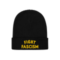 The Fight Fascism Hat features a black knit beanie with FIGHT FASCISM boldly embroidered in yellow on the cuff, making a clea