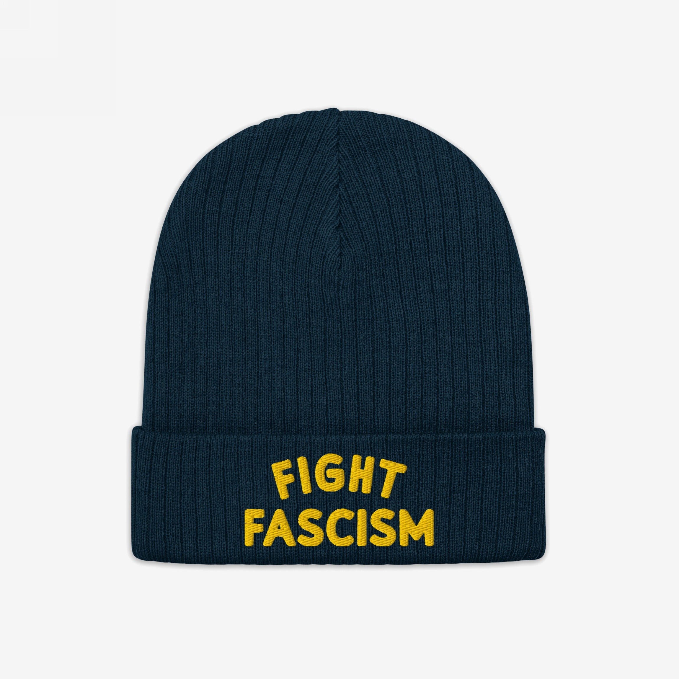 The Fight Fascism Hat is a dark-blue ribbed knit beanie with a folded cuff, featuring bold yellow FIGHT FASCISM embroidery, ideal for visible anti-fascist expression during marches or daily wear.