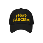 Fight Fascism Hat featuring bold yellow embroidery on a black baseball cap, symbolizing protest and visibility against hate, 