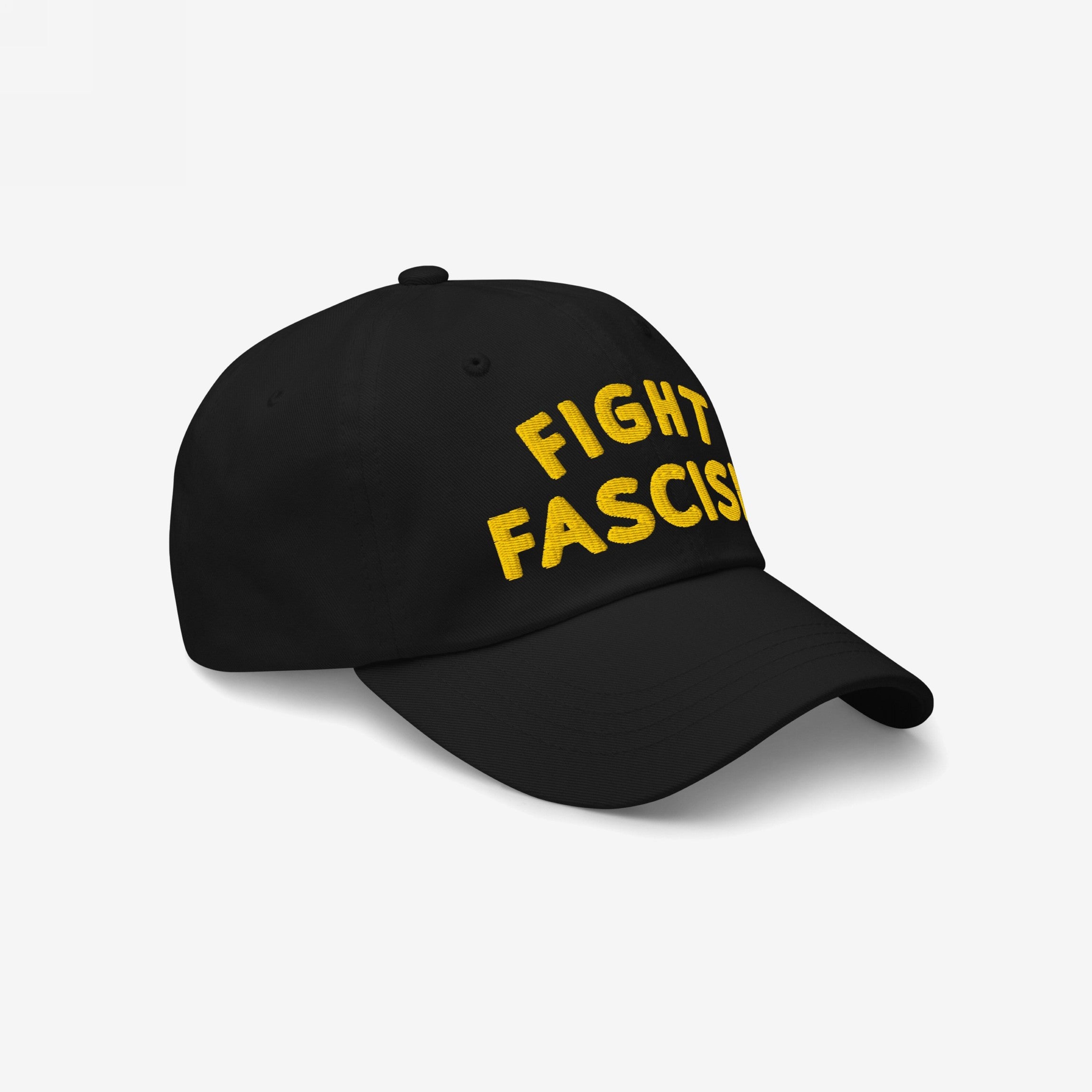 Fight Fascism Hat featuring bold yellow embroidery on a black cap, designed for visibility and protest. The angled view highlights its curved bill and crown, emphasizing its anti-fascist message.