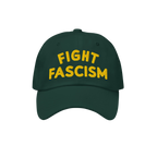 Fight Fascism Hat with bold yellow embroidery on a dark green cap, promoting anti-fascist visibility. Ideal for marches and d