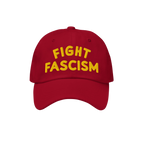 Red Fight Fascism Hat with a curved brim and bold yellow FIGHT FASCISM embroidery, designed for visible anti-fascist protest.