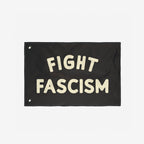 The Fight Fascism Flag features bold cream lettering on a black background, with metal grommets for hanging. Ideal for anti-fascist protests, it embodies a strong stance for equality and justice.