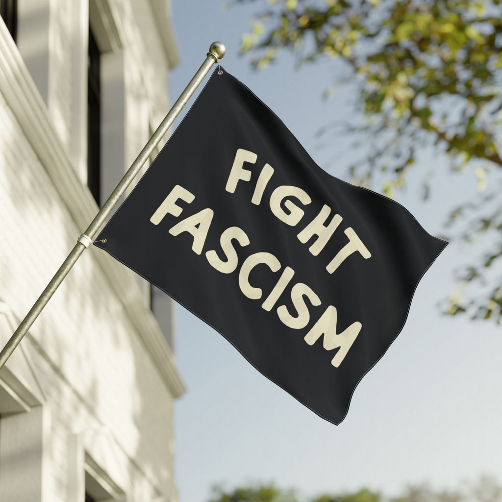 Fight Fascism Flag displayed outside, featuring bold cream text on a black background. Designed for equality advocates and anti-fascist protests, perfect for public demonstrations or personal expression.