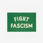Fight Fascism Flag with bold cream letters centered on a green background, featuring metal grommets along the left edge for easy hanging. Designed for anti-fascist activism and available in multiple sizes.
