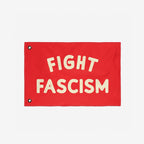 Fight Fascism Flag with bold cream letters centered on a red background, featuring metal grommets for easy hanging. Designed for anti-fascist protests, advocating equality and solidarity.
