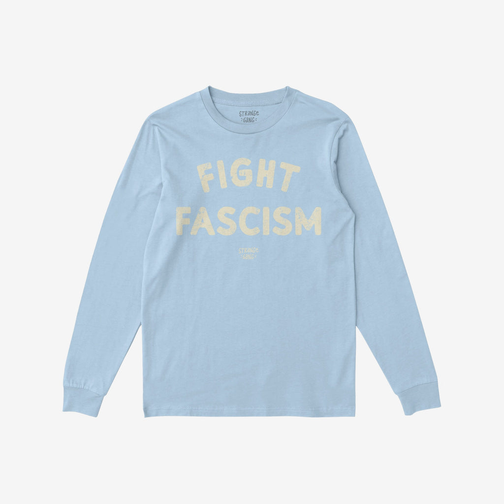 The Fight Fascism T-shirt features FIGHT FASCISM in large cream distressed letters on light-blue fabric, with subtle branding text below, embodying an anti-fascist message.