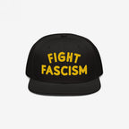 Black flat-brimmed hat with bold yellow FIGHT FASCISM embroidery on the front, promoting anti-fascist visibility. Ideal for protests, everyday wear, and supporting equality. Available in various hat styles.