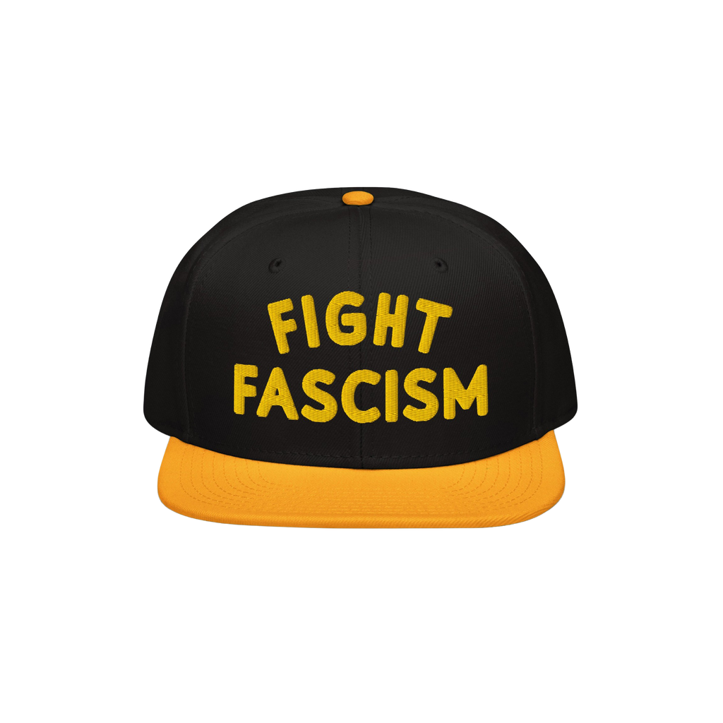 Black snapback-style cap with yellow brim and button, featuring bold yellow FIGHT FASCISM embroidery, embodying protest spiri