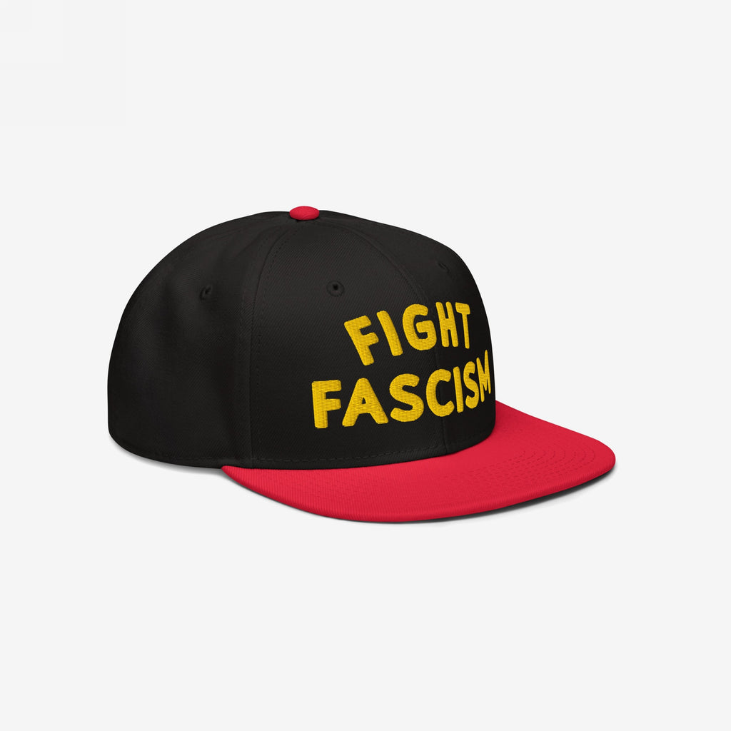 Fight Fascism Hat featuring a black crown with a red brim and top button, boldly embroidered with FIGHT FASCISM in yellow, designed for visibility and protest against hate and inequality.