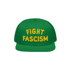 Green Fight Fascism Hat with yellow embroidered FIGHT FASCISM text on the front, featuring a flat brim. An anti-fascist state