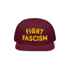 Fight Fascism Hat: A burgundy snapback cap with FIGHT FASCISM boldly embroidered in yellow, embodying protest and visibility.