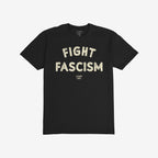Black T-shirt with bold, off-white “FIGHT FASCISM” lettering across the chest, embodying an anti-fascist message. Below, smaller text subtly identifies the designer, enhancing the shirt's statement against hate.