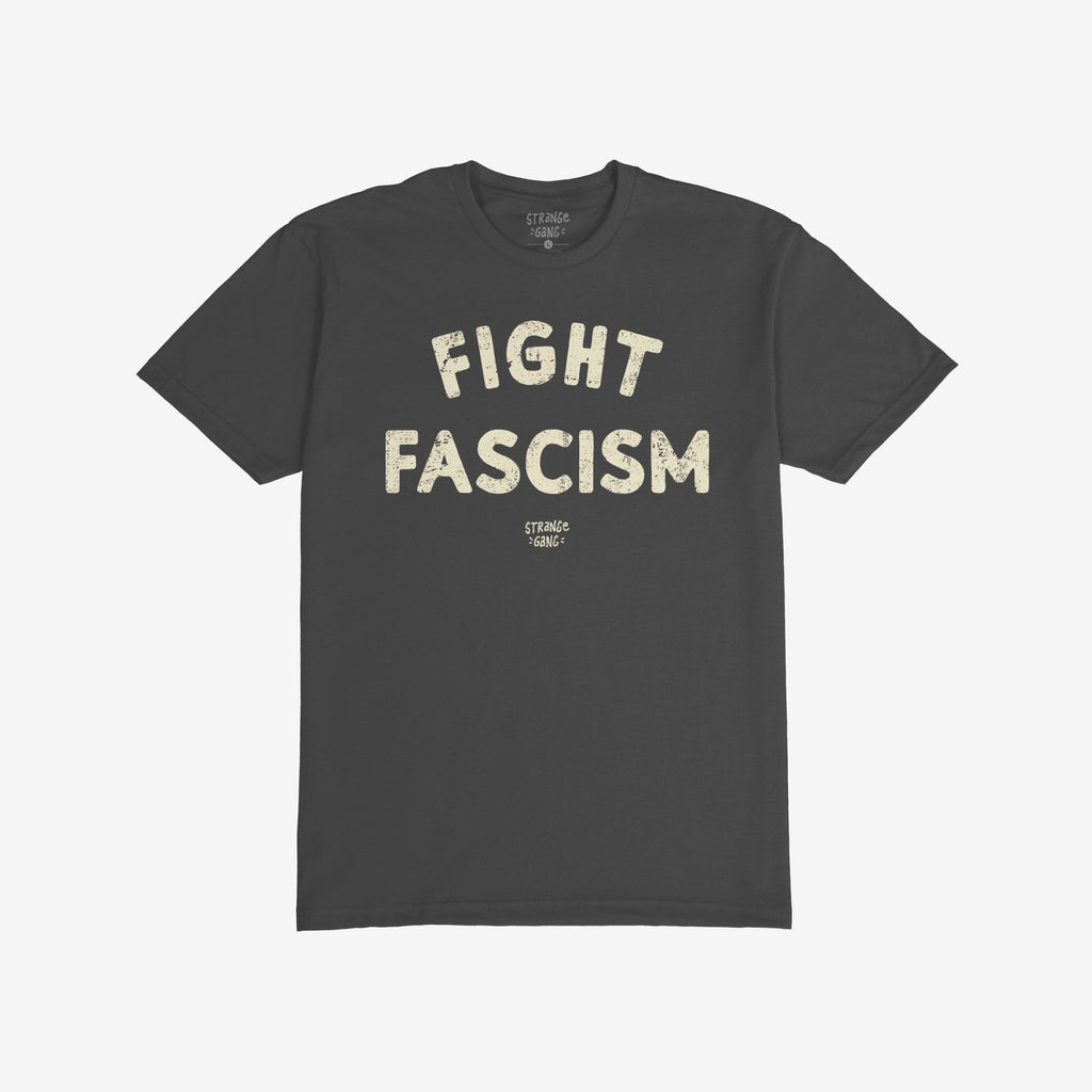Dark charcoal-gray Fight Fascism T-shirt with distressed off-white text, advocating against fascism. Brand name appears below. Laid flat on a white background, embodying activism and social justice ethos.