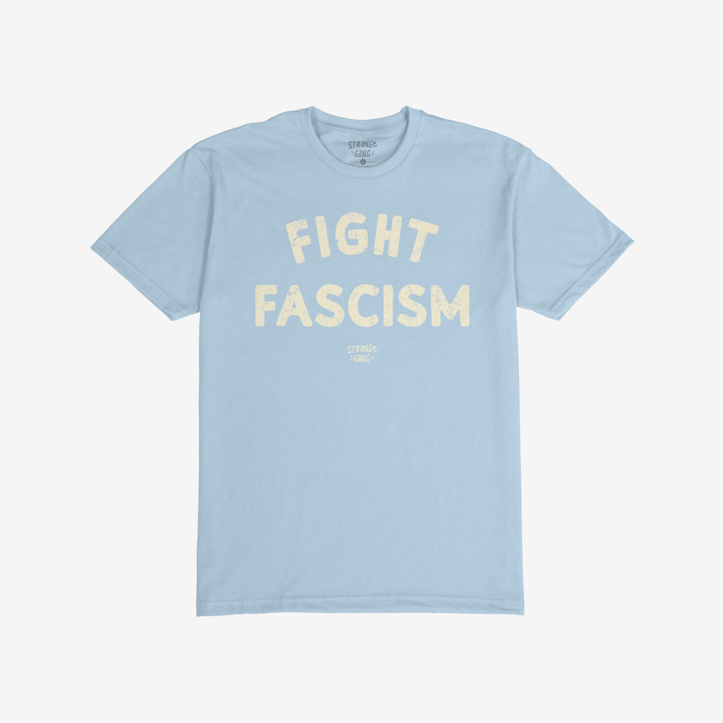 Light-blue Fight Fascism T-shirt with short sleeves, featuring large, off-white distressed print slogan and small logo below. Ideal for protests, activism, and spreading anti-fascist messages.