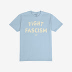 Light-blue Fight Fascism T-shirt with short sleeves, featuring large, off-white distressed print slogan and small logo below. Ideal for protests, activism, and spreading anti-fascist messages.