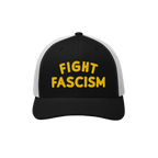 Trucker-style black-and-white Fight Fascism Hat with bold yellow embroidery. Ideal for protests or daily wear, aligning with 