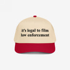 Film The Police Hat features a cream crown with a red bill, boldly embroidered with it’s legal to film law enforcement, offering a stylish reminder of rights and accountability.