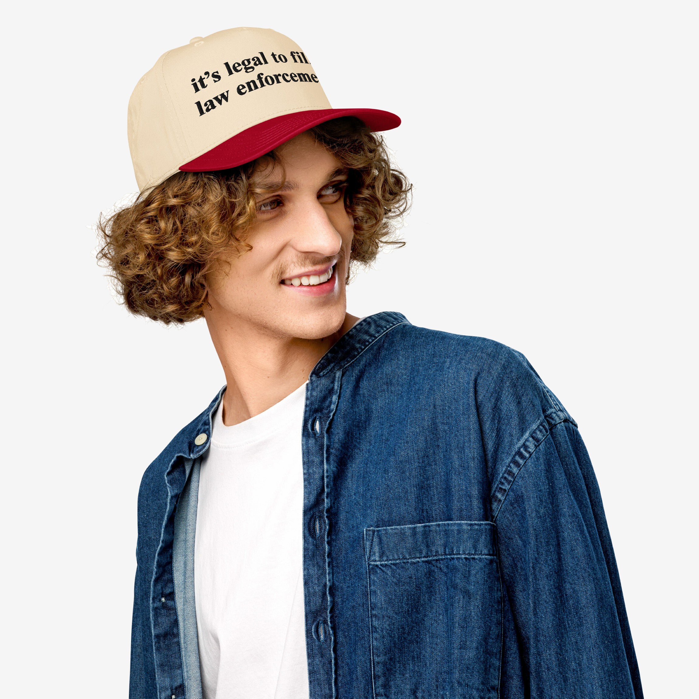 Young man in a denim shirt wearing the Film The Police Hat, a two-tone baseball cap with it’s legal to film law enforcement slogan, reflecting protest gear for police accountability.