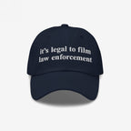 Film The Police Hat: A navy-blue dad hat featuring white embroidered text, it’s legal to film law enforcement, embodying a bold statement on police accountability and individual rights.