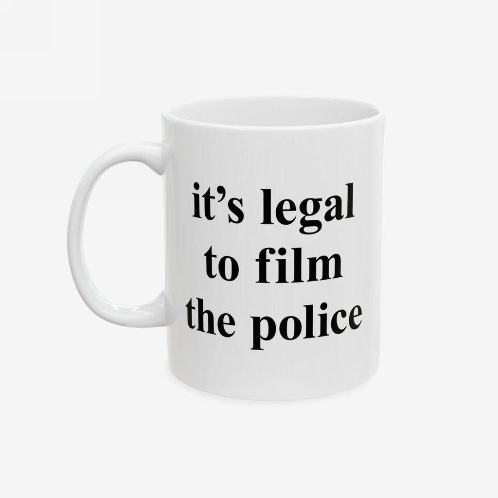 Film The Police Mug with bold black text on a plain white ceramic surface, reminding users it's legal to film police. Available in 11 oz. and 15 oz., microwave and dishwasher safe.