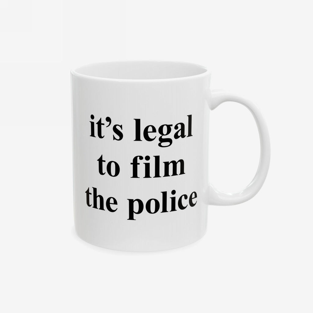 Film The Police Mug featuring bold black text, it's legal to film the police, on a white ceramic surface. Available in 11 oz. and 15 oz., it's dishwasher and microwave safe.