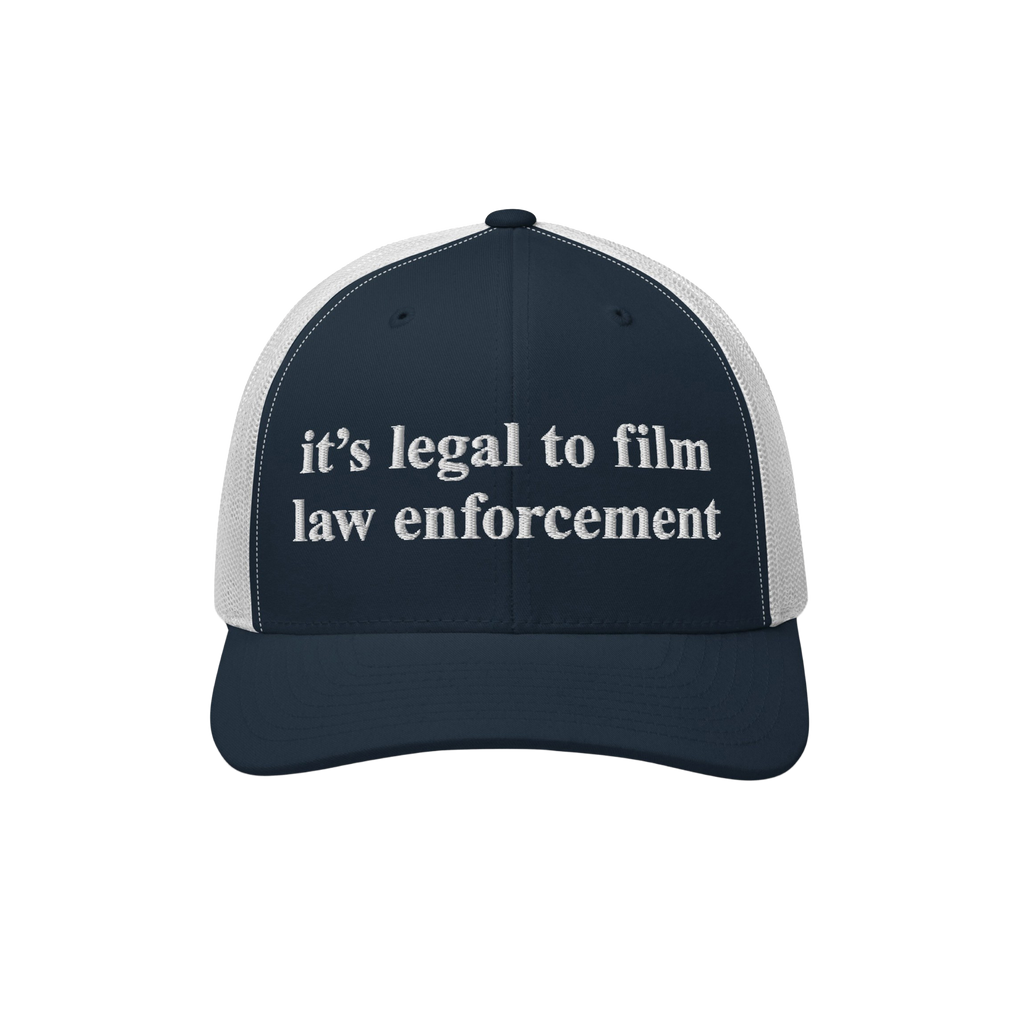 Navy-blue and white mesh trucker cap with “it’s legal to film law enforcement” embroidered in white on the front, repre