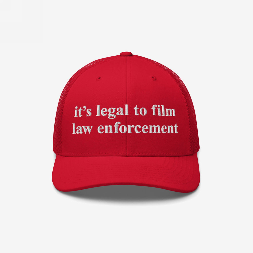 Red mesh-back trucker cap with white embroidered it’s legal to film law enforcement text. The Film The Police Hat embodies protest spirit and police accountability awareness, ideal for rights-conscious individuals.