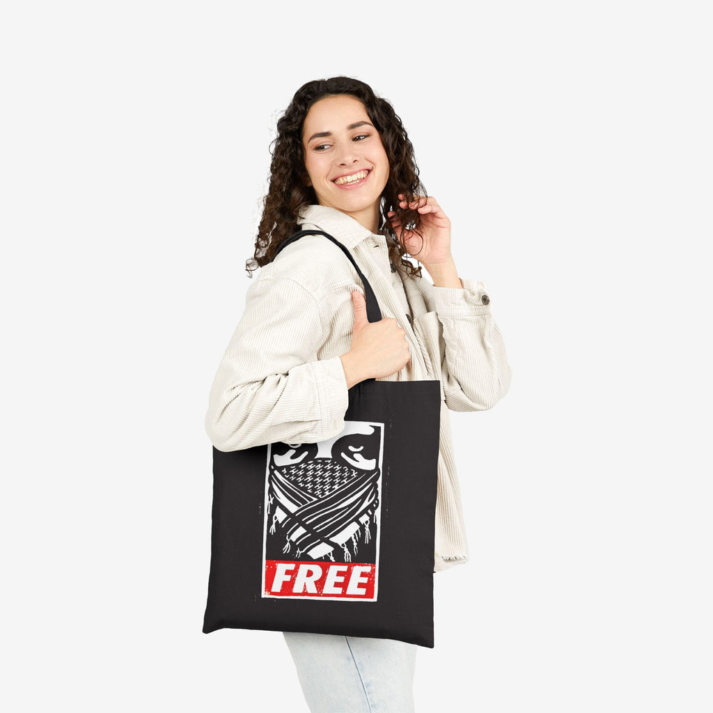 Free Palestine JULZ Tote Bag carried by young woman, features bold graphic of eyes and scarf-like pattern with FREE in red. A statement piece supporting Palestinian freedom, perfect for activists.