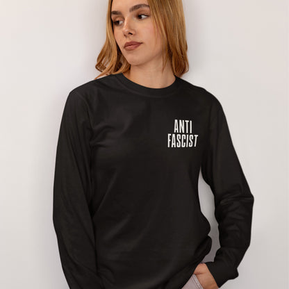 Person wearing Fuck 'Em All Back Print T-shirt with “ANTI FASCIST” on chest, against a light background. Shirt designed for activism, available in men/unisex and kids sizes.