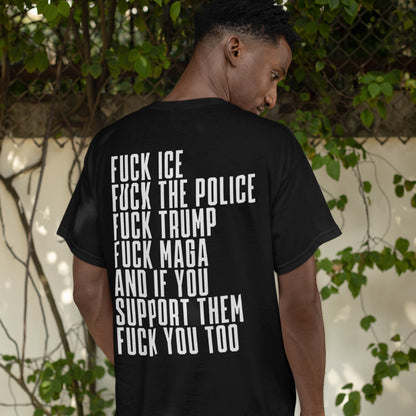 Person wearing the Fuck 'Em All Back Print T-shirt, featuring bold text denouncing ICE, police, Trump, and their supporters, standing by a fence with foliage.