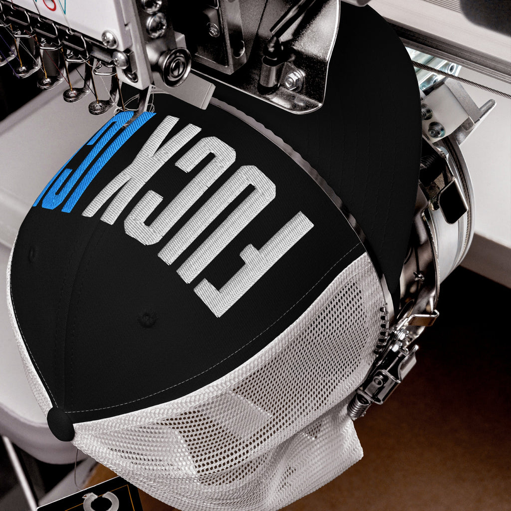 Trucker-style Fuck ICE hat in embroidery machine, stitching visible, with white mesh back and FUSION in progress, showcasing bold values and expressive design.