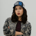Young woman wearing a FUCK ICE hat with bold 3D embroidery, crossing her arms against a light background. The cap embodies bold activism and personal expression.
