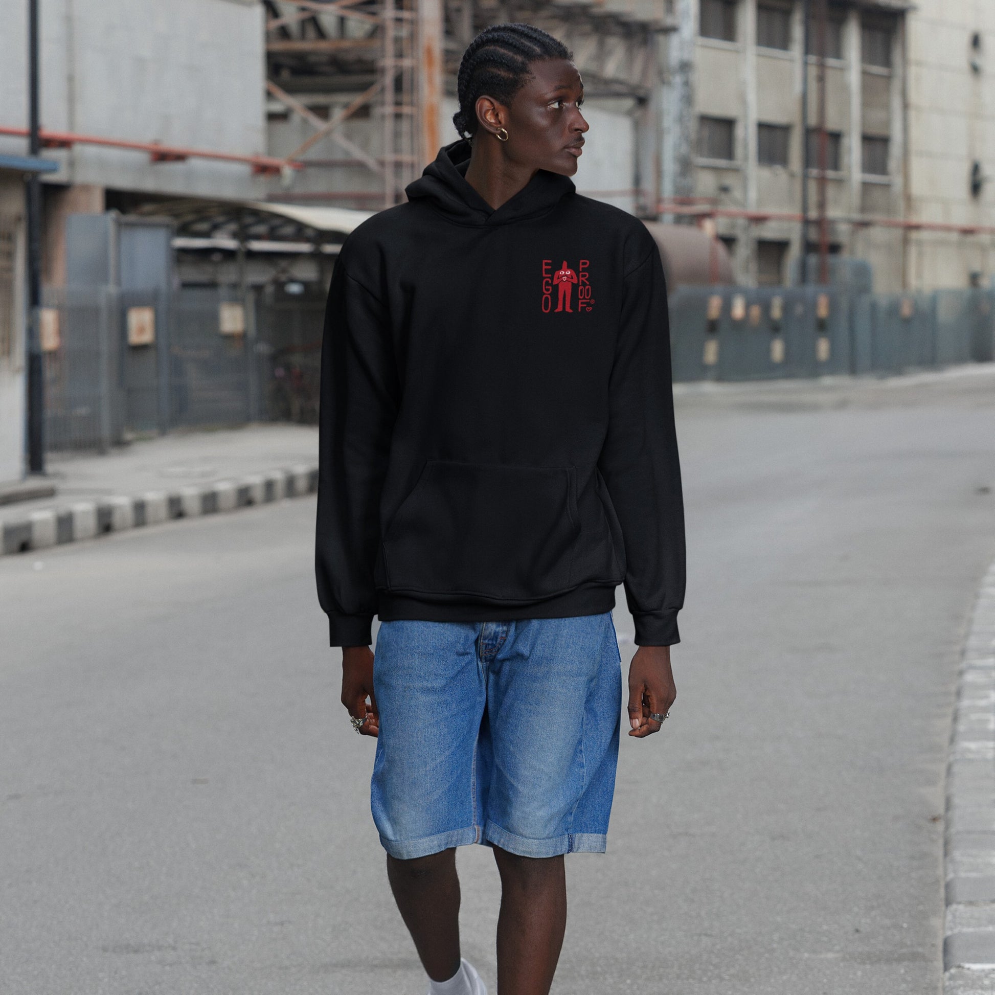 Fucks To Give Hoodie on young person strolling a city street. Black hoodie with small red graphic front, bold sarcastic message on back. Paired with denim shorts, embodying unapologetic disengagement.